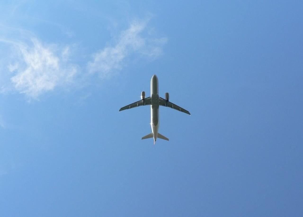 Passenger airplane flying overhead in a clear blue sky
